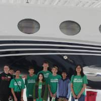 Green team poses in front of an Amway private jet on a STEPS 2026 field trip